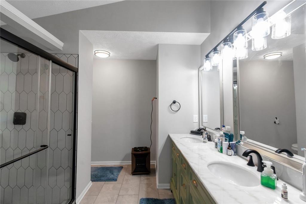 3152 Spruce Way Atlanta, GA 30349 - Photo 33 of 42 a bathroom with a double vanity sink a large mirror and shower
