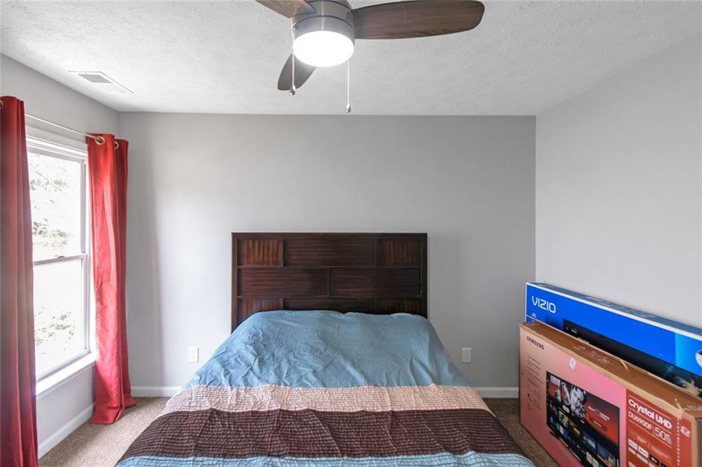 3152 Spruce Way Atlanta, GA 30349 - Photo 40 of 42 a bedroom with a bed and a potted plant on the dresser