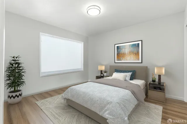 a bedroom with a bed and a potted plant