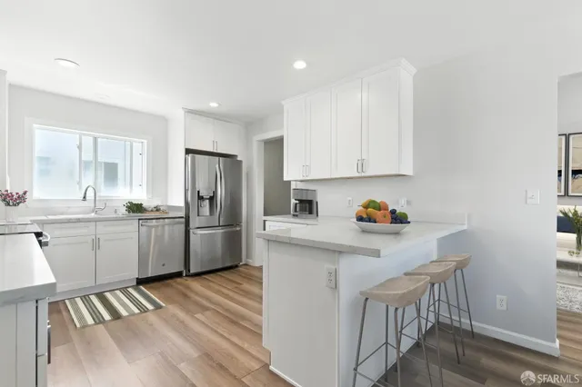 a kitchen with granite countertop white cabinets and stainless steel appliances