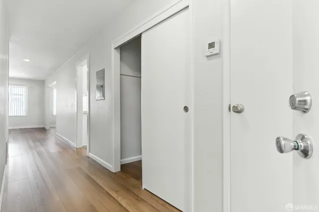 a view of a hallway with wooden floor