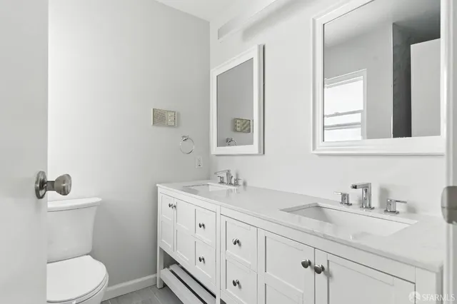a bathroom with a granite countertop toilet sink and mirror
