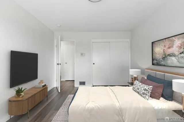 a bedroom with a bed and a flat screen tv