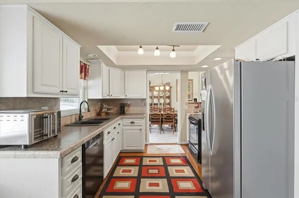 a kitchen with stainless steel appliances a stove a sink and a refrigerator