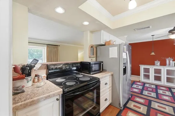 a kitchen with stainless steel appliances kitchen island granite countertop a refrigerator and a sink