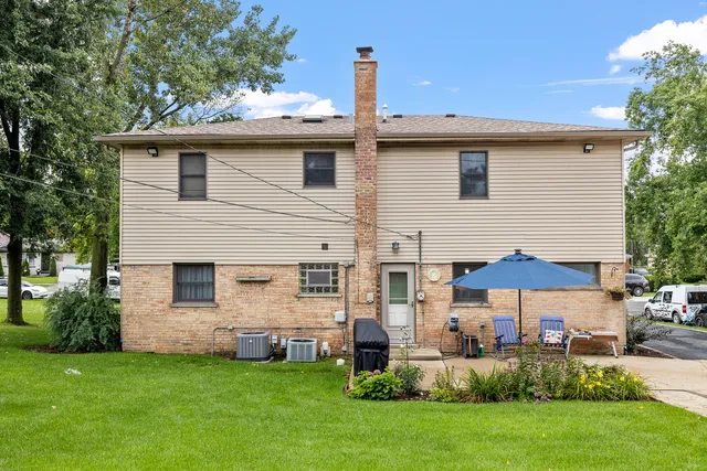 a view of a house with a yard and sitting area