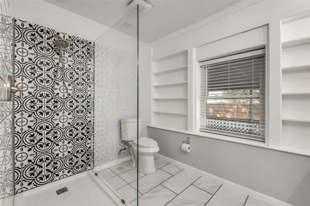 a bathroom with a toilet and a shower