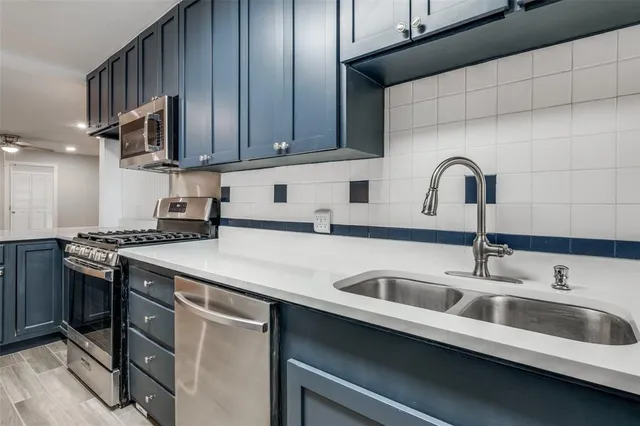 a kitchen with stainless steel appliances a sink a stove and cabinets