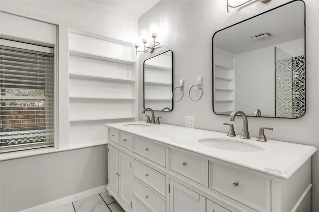 a bathroom with double sink and a mirror