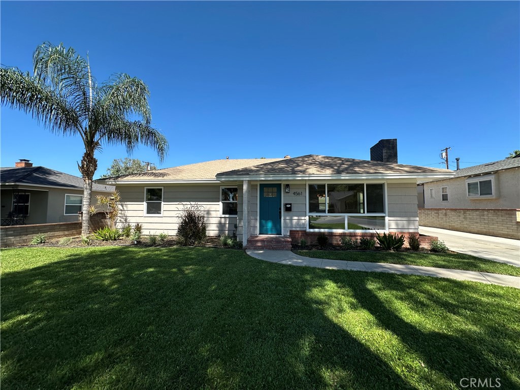 a front view of a house with a garden and yard