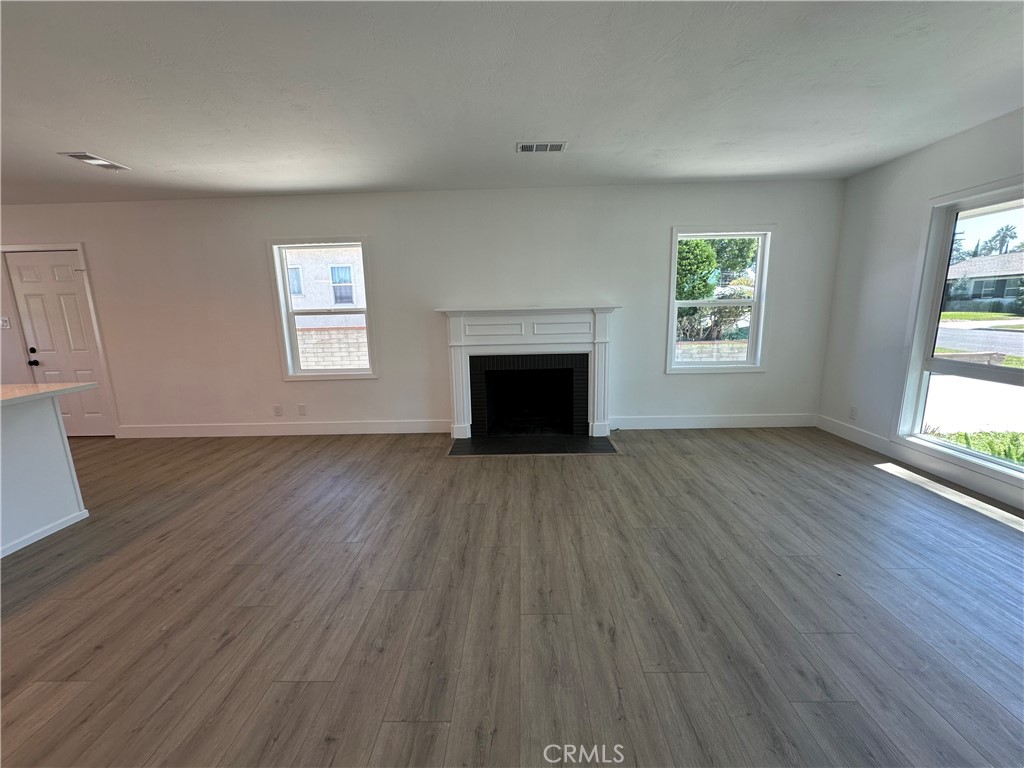 4561 Cover Street Riverside, CA 92506 - Photo 11 of 47 an empty room with wooden floor windows and fireplace