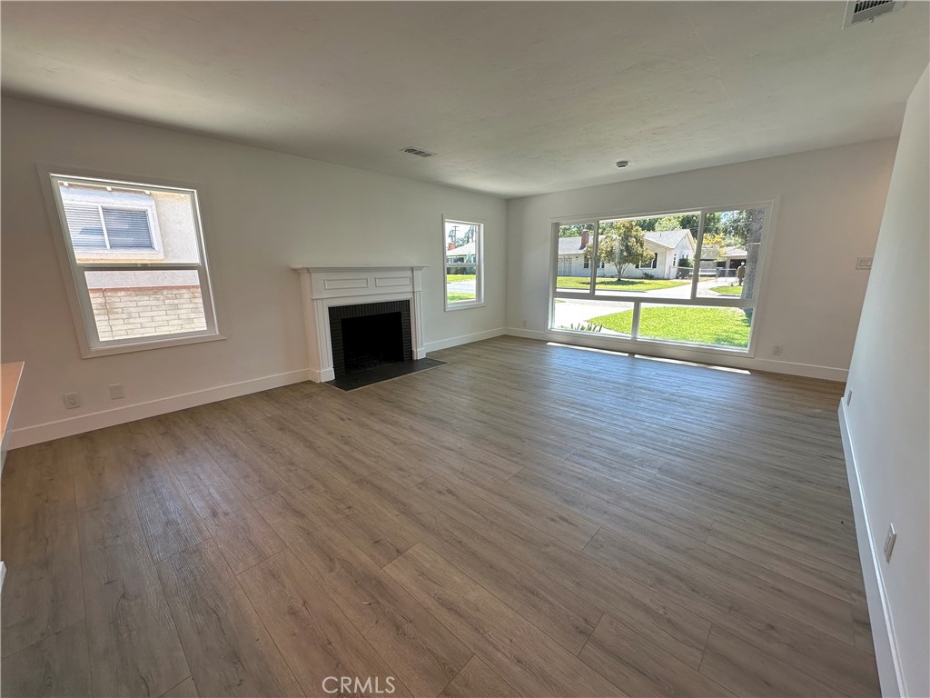 4561 Cover Street Riverside, CA 92506 - Photo 12 of 47 an empty room with wooden floor fireplace and windows