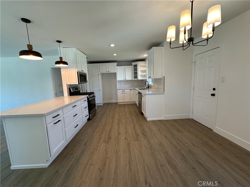 4561 Cover Street Riverside, CA 92506 - Photo 15 of 47 a kitchen with sink cabinets and wooden floor