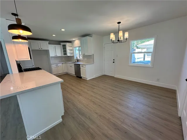 a kitchen with a wooden floor and a refrigerator