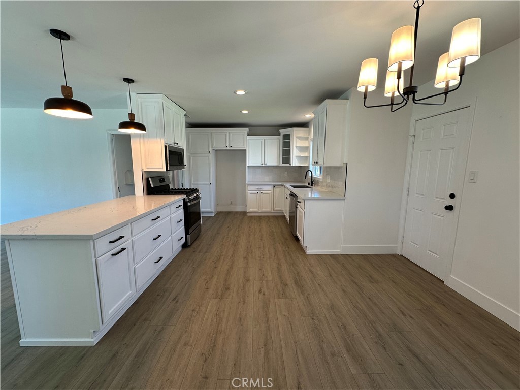 4561 Cover Street Riverside, CA 92506 - Photo 17 of 47 a kitchen with cabinets a sink and wooden floor