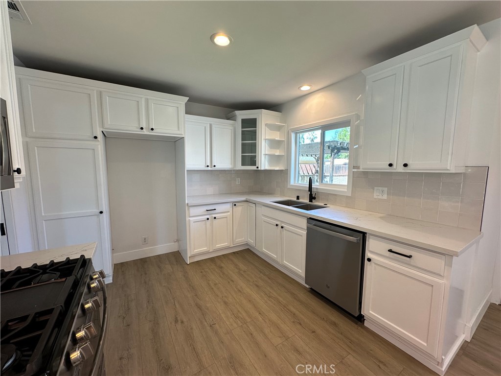 4561 Cover Street Riverside, CA 92506 - Photo 18 of 47 a kitchen with granite countertop white cabinets and white appliances