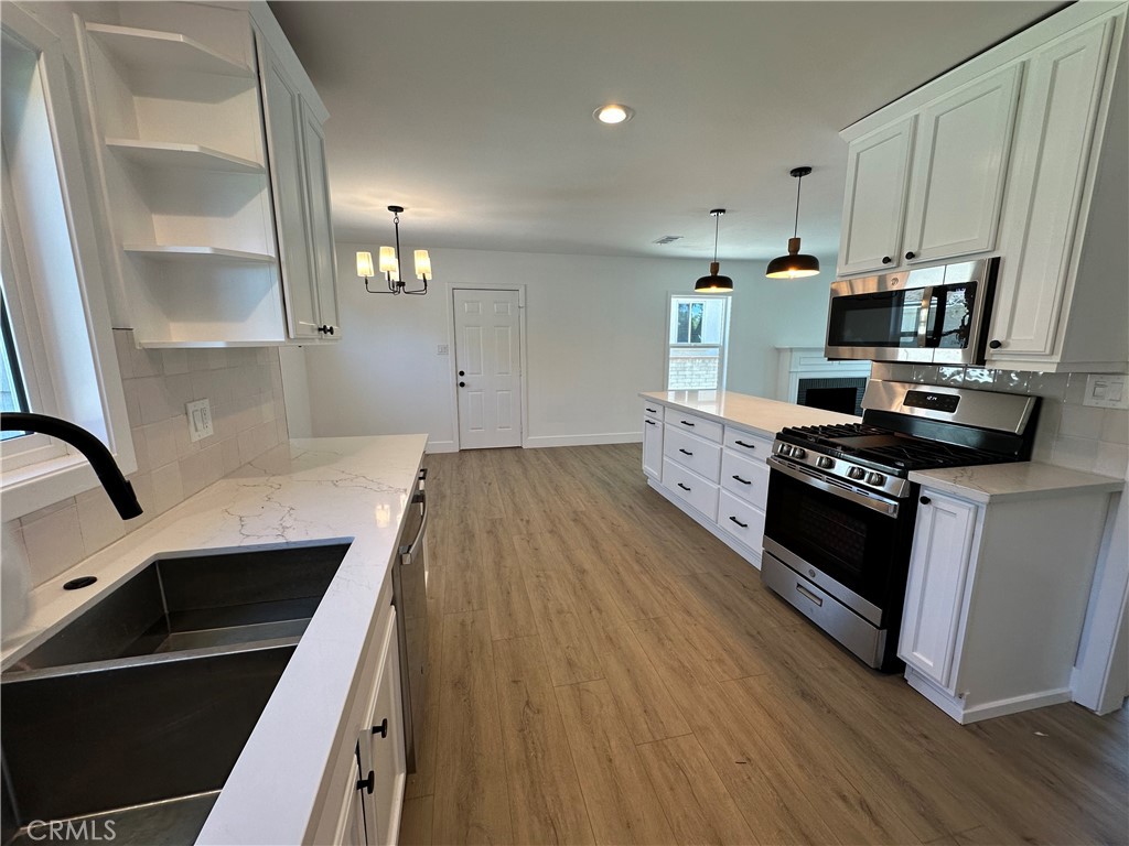 4561 Cover Street Riverside, CA 92506 - Photo 19 of 47 a kitchen with granite countertop a sink a stove top oven and cabinetry