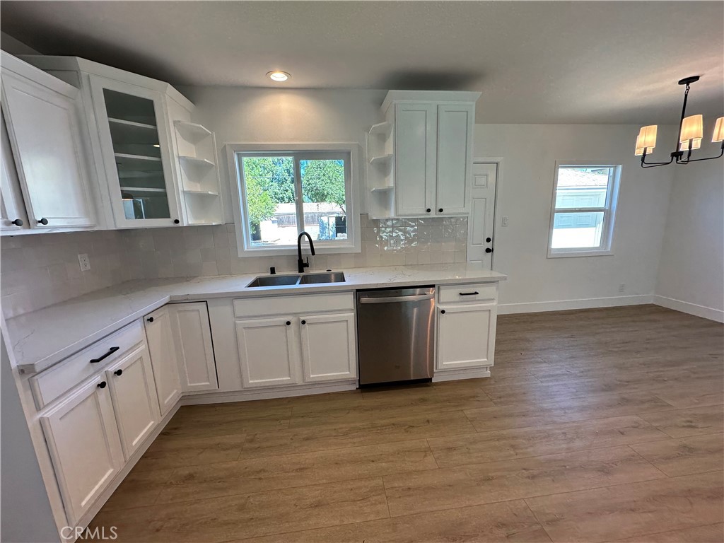 4561 Cover Street Riverside, CA 92506 - Photo 20 of 47 a kitchen with granite countertop white cabinets a sink a window and stainless steel appliances