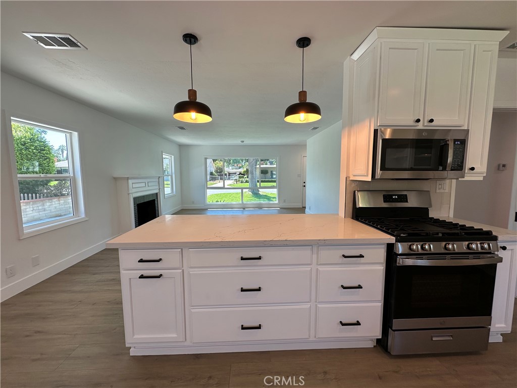 4561 Cover Street Riverside, CA 92506 - Photo 22 of 47 a kitchen with a stove and a chandelier