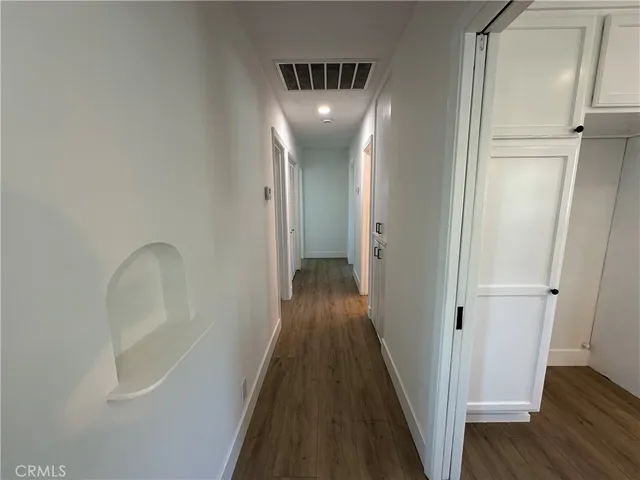 a view of a hallway with wooden floor