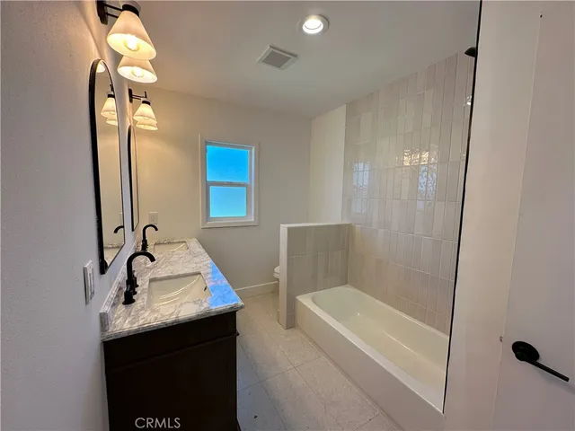 a bathroom with a sink a tub and a mirror