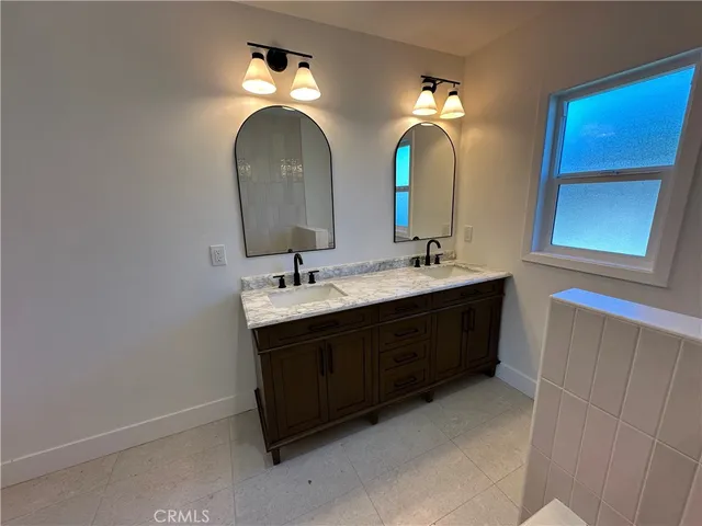a bathroom with a double vanity sink and a mirror