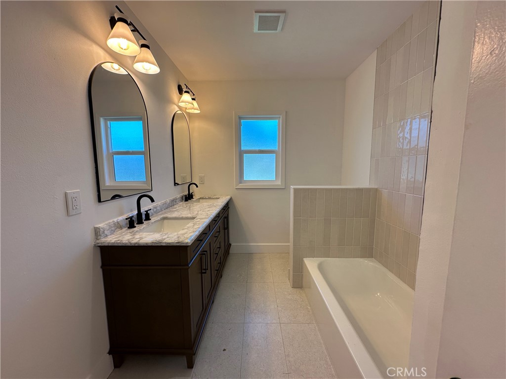 4561 Cover Street Riverside, CA 92506 - Photo 27 of 47 a bathroom with a double vanity sink mirror and bathtub