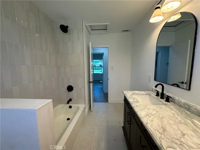 a bathroom with a granite countertop sink a mirror and shower