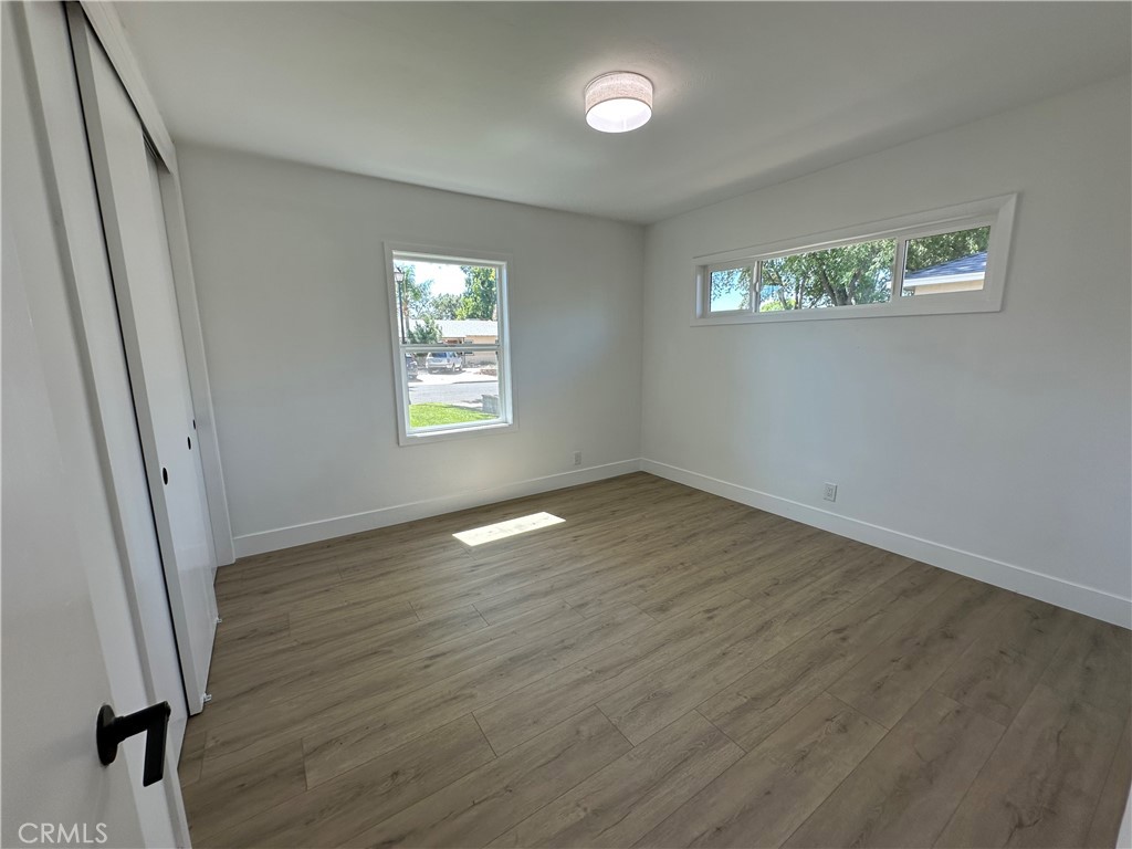 4561 Cover Street Riverside, CA 92506 - Photo 32 of 47 a view of an empty room with wooden floor and a window
