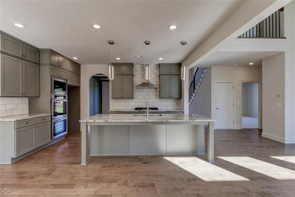 3055 Reserve Court Southwest Conyers, GA 30094 - Photo 10 of 33 a large kitchen with stainless steel appliances kitchen island a large counter top and a stove top oven