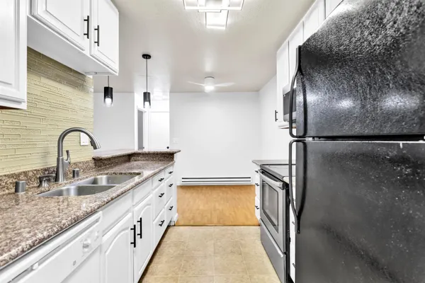 a kitchen with granite countertop a sink stainless steel appliances and cabinets