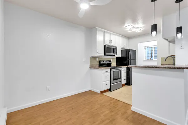 a kitchen with granite countertop a sink a counter top space stainless steel appliances and cabinets