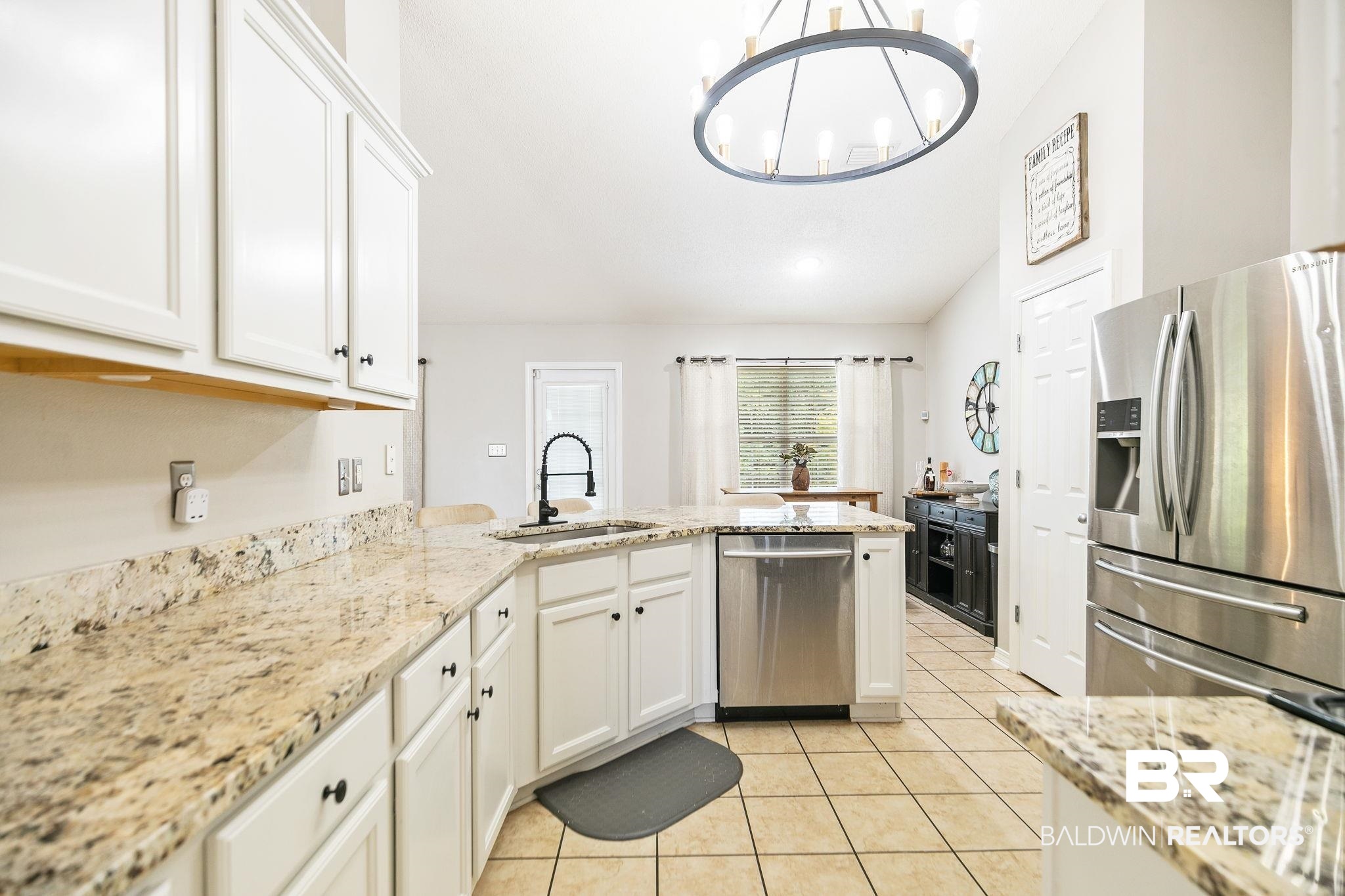 28246 Turkey Branch Drive Daphne, AL 36526 - Photo 14 of 41 Kitchen featuring light tile patterned flooring, stainless steel appliances, a chandelier, sink, and kitchen peninsula