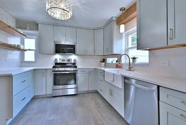 a kitchen with cabinets stainless steel appliances a sink and a window