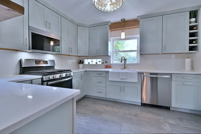 a kitchen with stainless steel appliances a stove a sink and a microwave