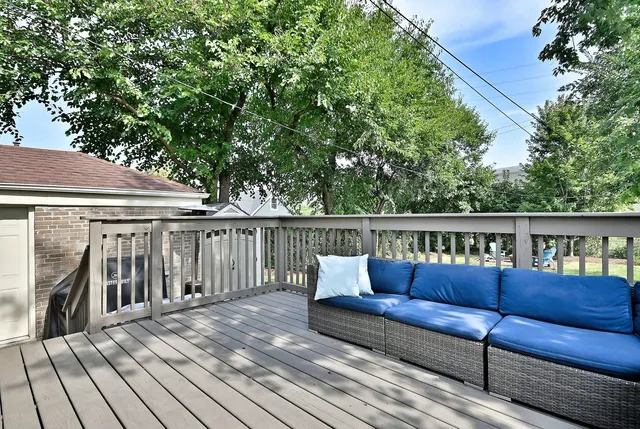 a roof deck with couches and wooden fence