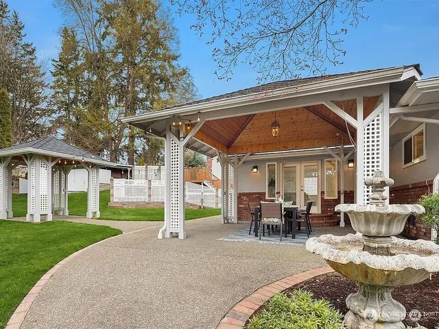 a view of a patio with couches table and chairs and garden