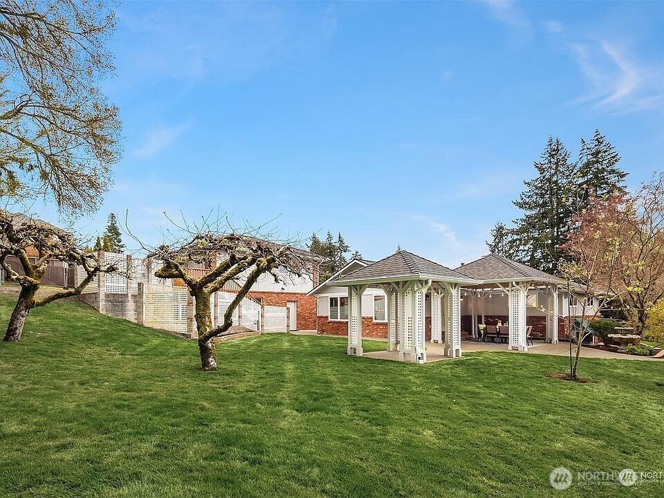 405 240th Street Southwest Bothell, WA 98021 - Photo 16 of 29 a view of a white house with a big yard and large trees