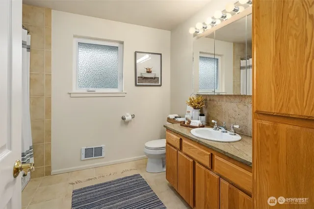a bathroom with a sink a toilet and mirror