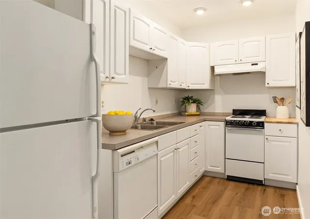 a kitchen with white cabinets and white appliances