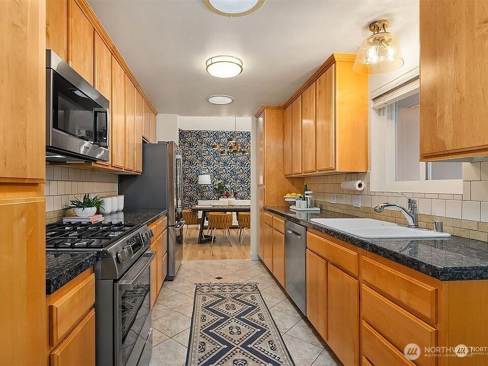 405 240th Street Southwest Bothell, WA 98021 - Photo 8 of 29 a kitchen with stainless steel appliances a sink stove top oven and cabinets