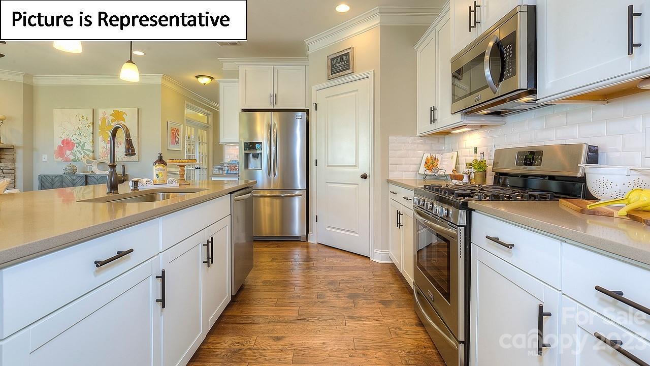4249 Millstream Road Denver, NC 28037 - Photo 14 of 34 a kitchen with stainless steel appliances a sink a stove top oven a refrigerator white cabinets and wooden floor