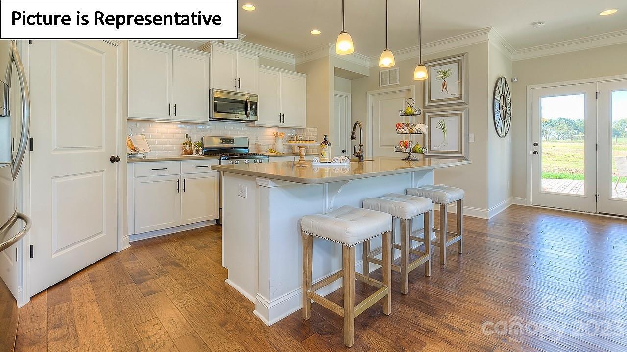 4249 Millstream Road Denver, NC 28037 - Photo 18 of 34 a kitchen with stainless steel appliances granite countertop a stove top oven a sink island and a refrigerator