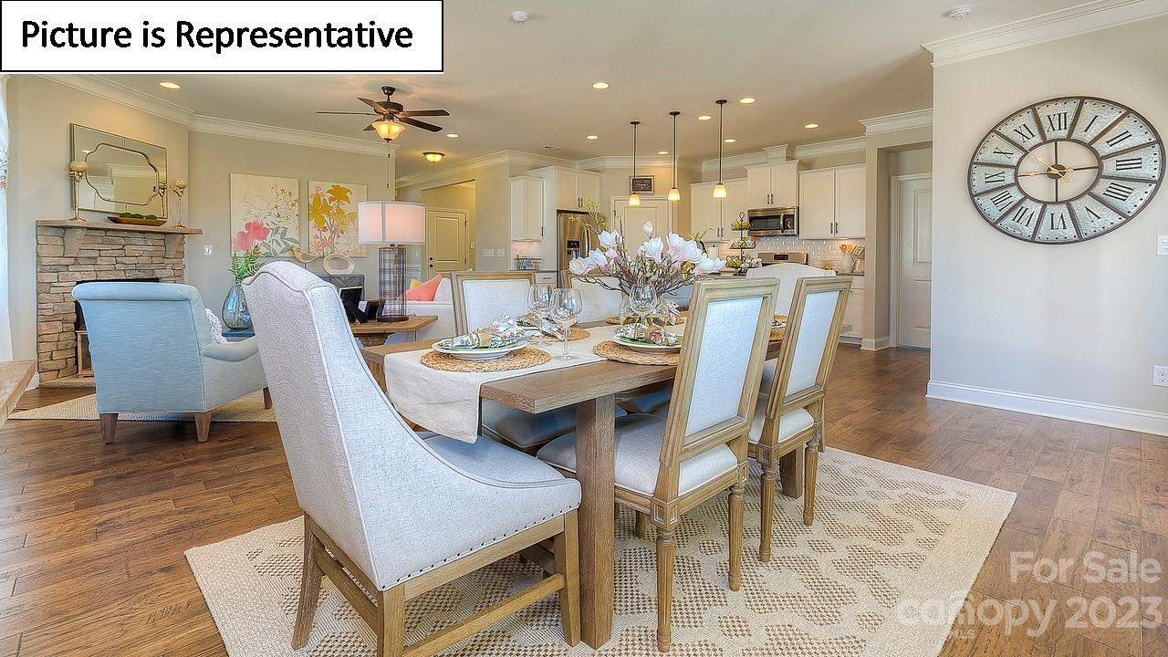 4249 Millstream Road Denver, NC 28037 - Photo 9 of 34 a dining room with furniture a rug a fireplace and a chandelier