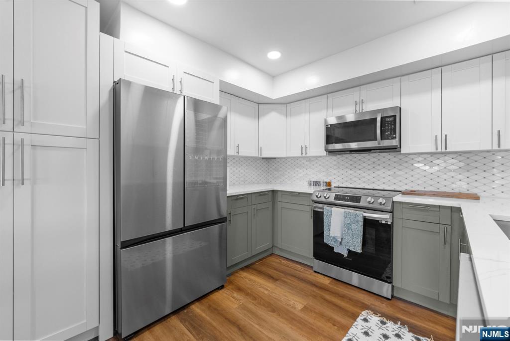 101 Highway 5, Unit 206 Edgewater, NJ 07020 - Photo 14 of 48 a kitchen with granite countertop a refrigerator stove and microwave
