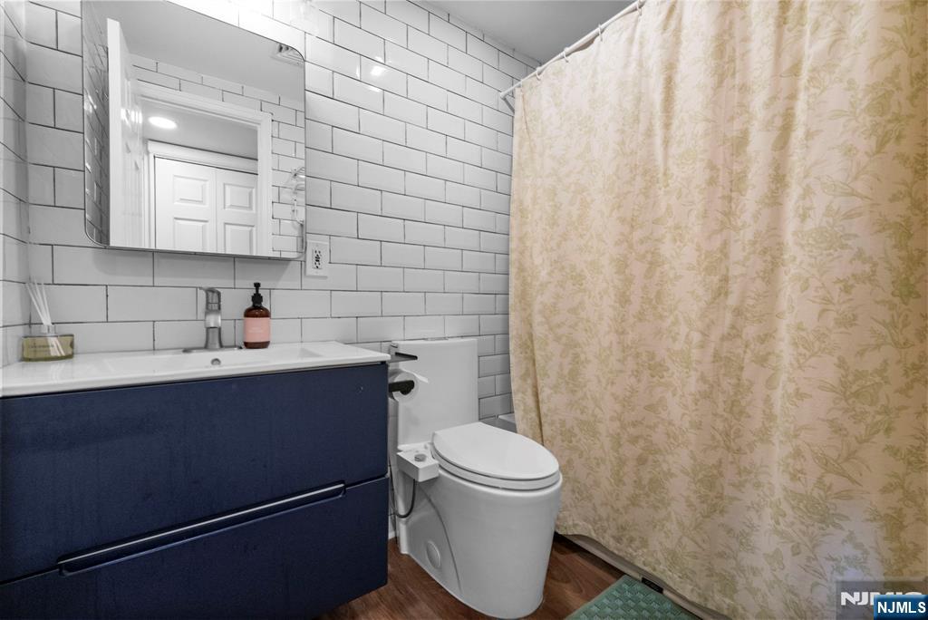101 Highway 5, Unit 206 Edgewater, NJ 07020 - Photo 16 of 48 a bathroom with a sink a toilet and shower curtain