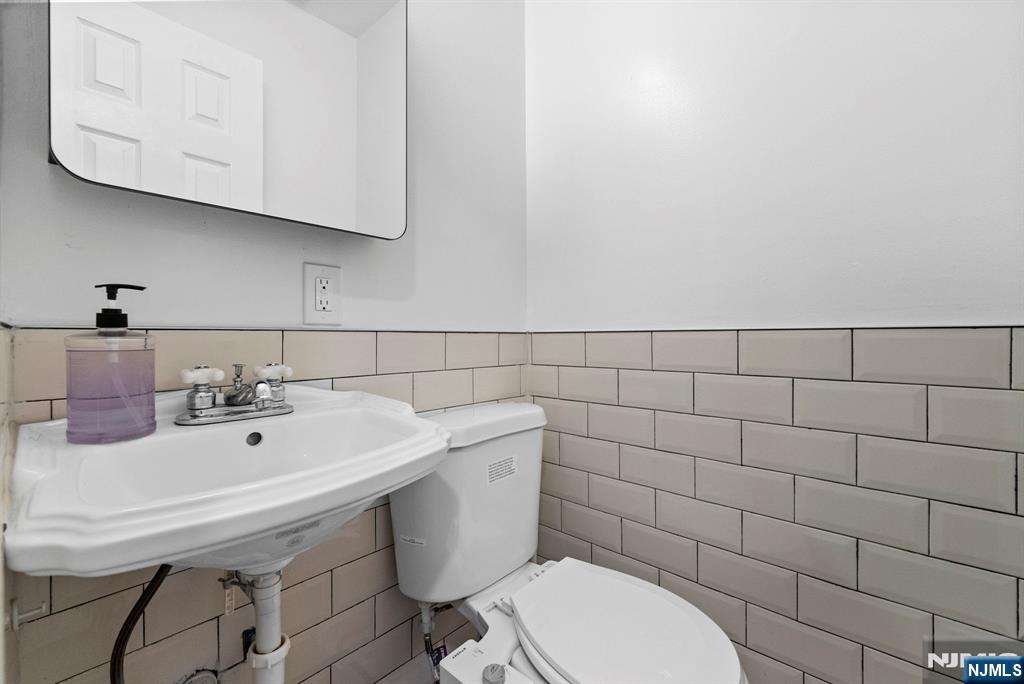 101 Highway 5, Unit 206 Edgewater, NJ 07020 - Photo 28 of 48 a bathroom with a sink a toilet and mirror