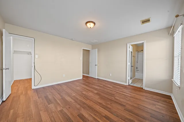 a view of an empty room with wooden floor
