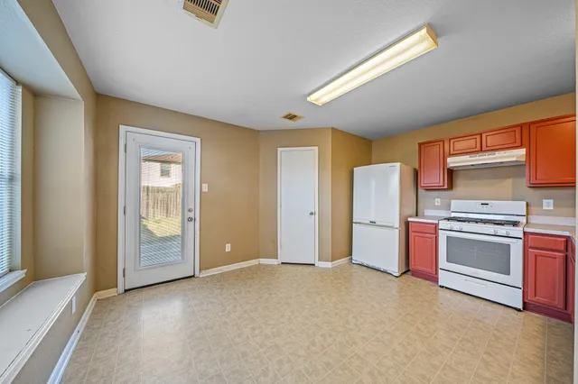 a view of a kitchen with refrigerator and stove top oven