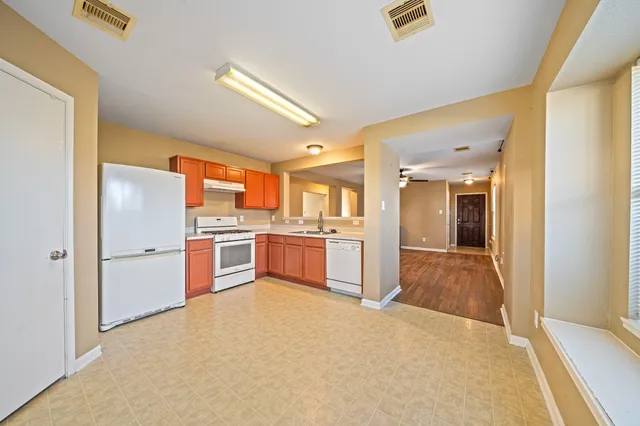 a kitchen with refrigerator cabinets and large window